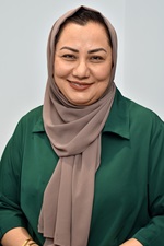 A headshot portrait of Fatimi Faqiri, smiling and looking directly at the camera