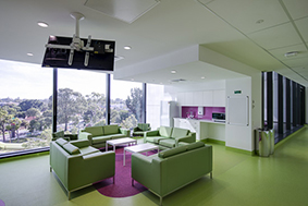 Green couches overlooking trees in a family sitting area at PCH