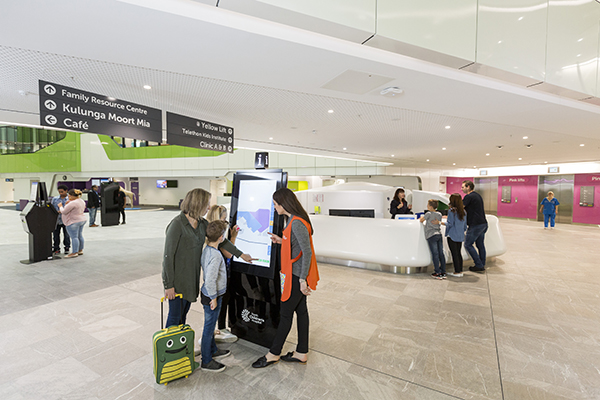 Mum with kids and a PCH Volunteer at the Wayfinding kiosk